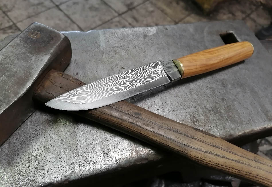 couteau avec lame en damas multi barreaux en stage de coutellier