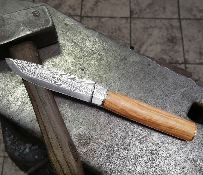 couteau avec lame en damas multi barreaux en stage de coutellier